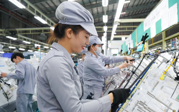 Công nhân thao tác trên dây chuyền lắp ráp linh kiện trong môi trường điều hòa ổn định